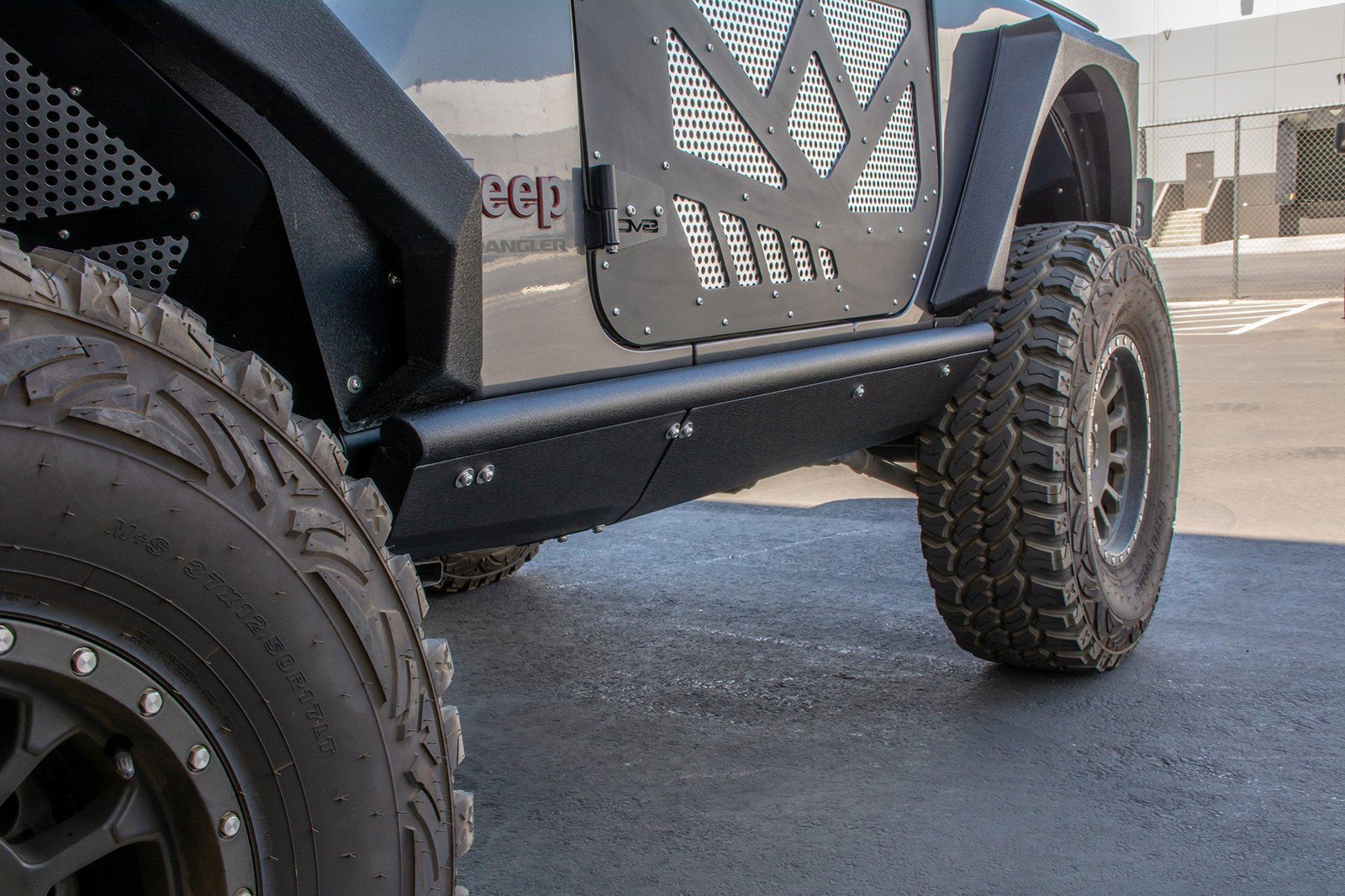 DV8 Offroad boatside rock slider bolted under a 2-door Jeep Wrangler JL
